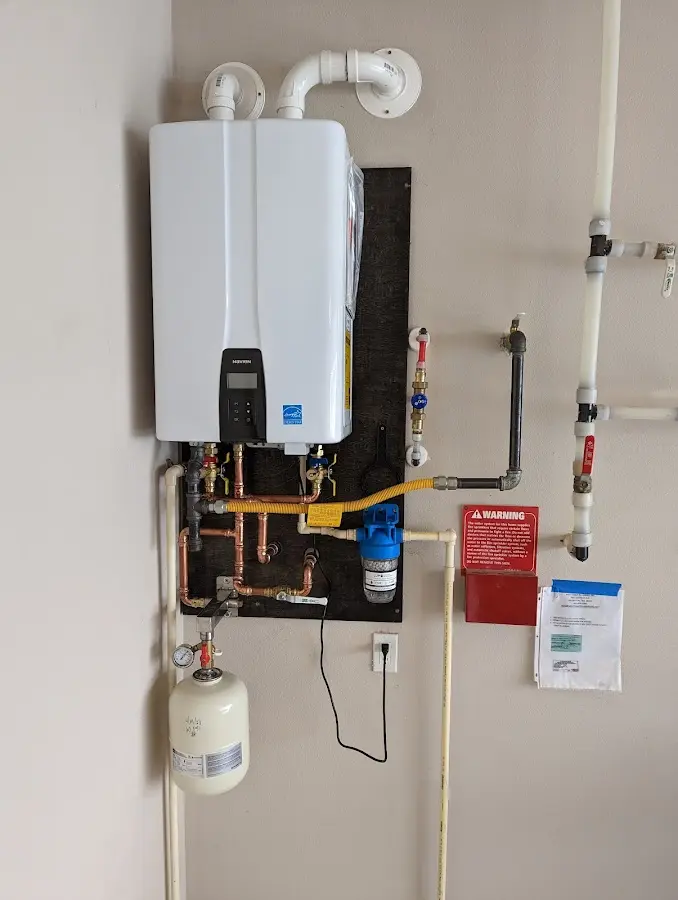 Professional plumber installing copper piping in a Louisburg home